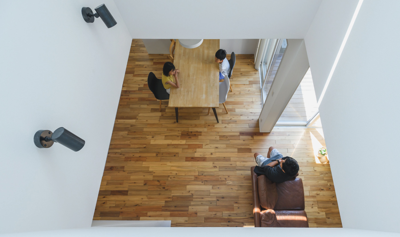 吹き抜けと階段で上下が連続する室内。2階ホールが見える 吹き抜け空間に差し込む光。上下階の視線がつながる