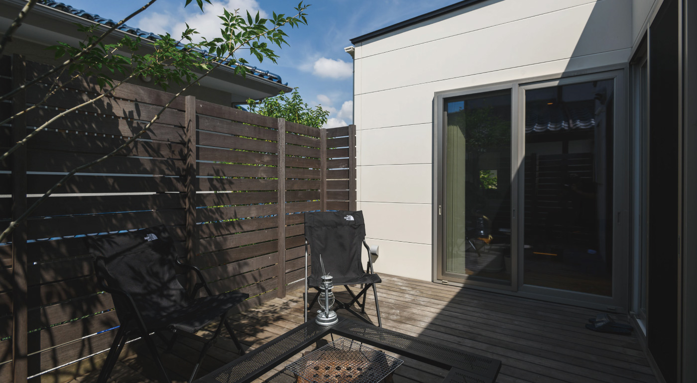 プライベートガーデンとウッドデッキ。LDKとつながる外空間 アプローチの庭と奥の庭がある、二庭構成の外構